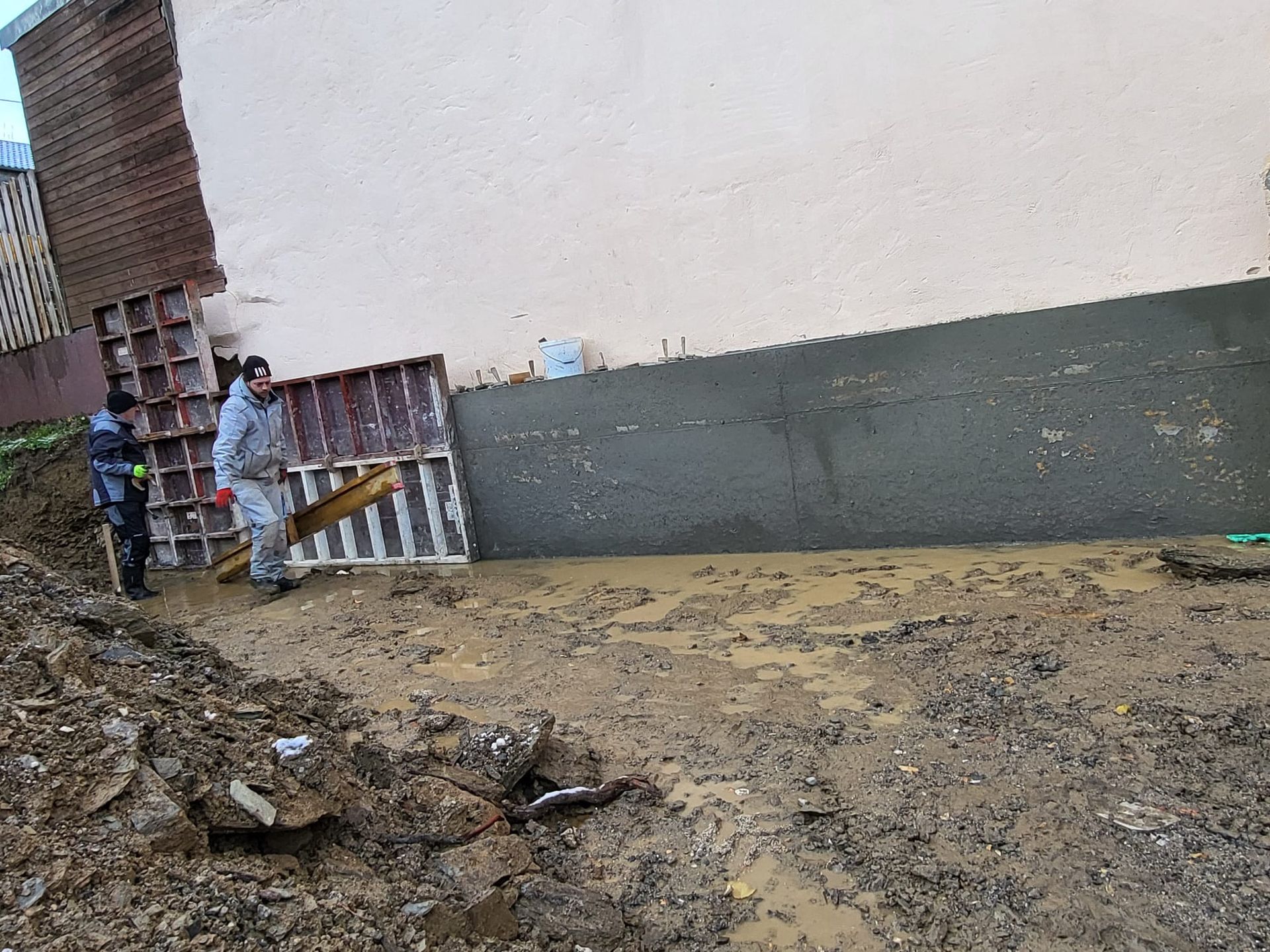 Eine Gruppe von Leuten arbeitet auf einer Baustelle neben einem Gebäude.