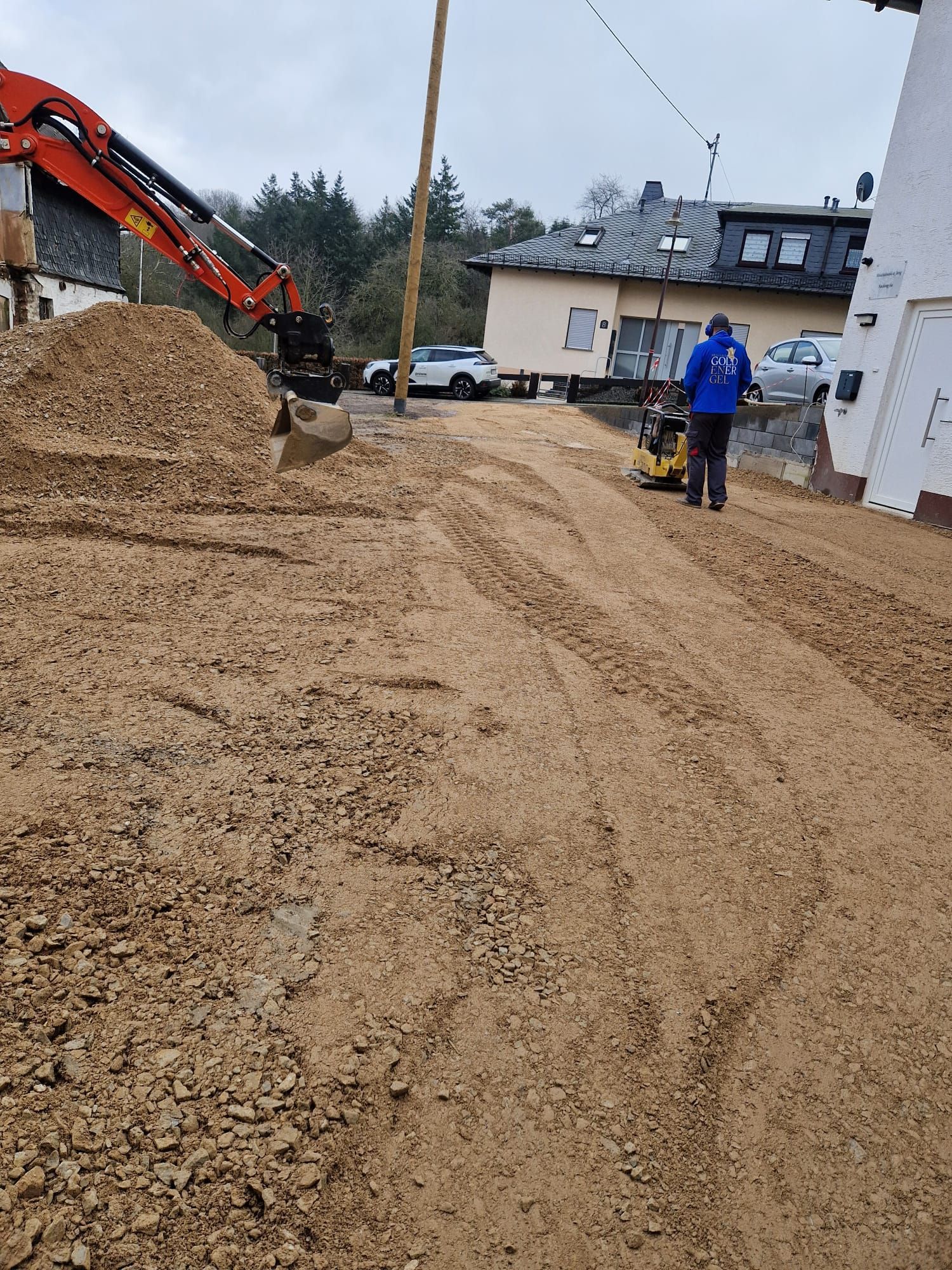 Ein Mann läuft einen Feldweg entlang neben einem großen Erdhaufen.