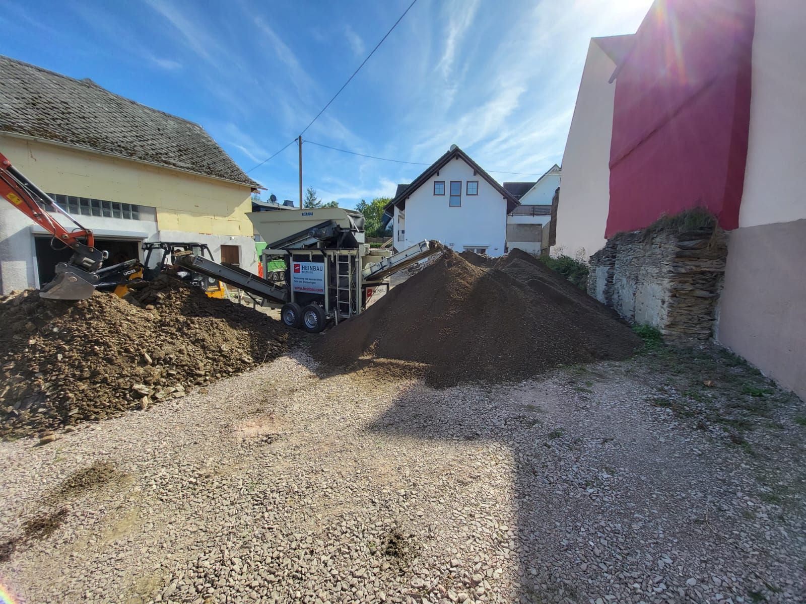 Vor einem Gebäude liegt ein Erdhaufen.