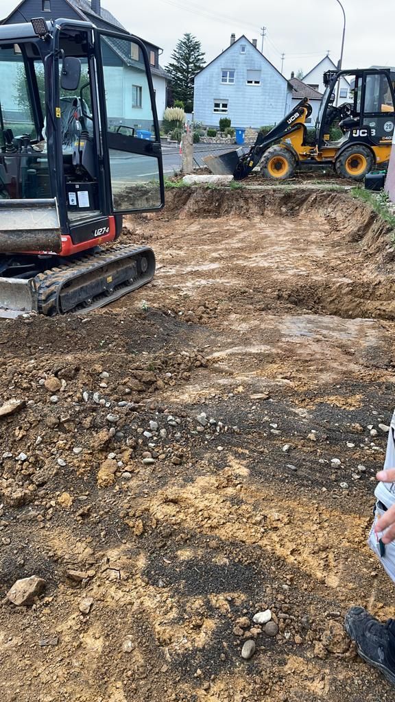 Eine Person steht auf einem Feld neben einem Bulldozer.