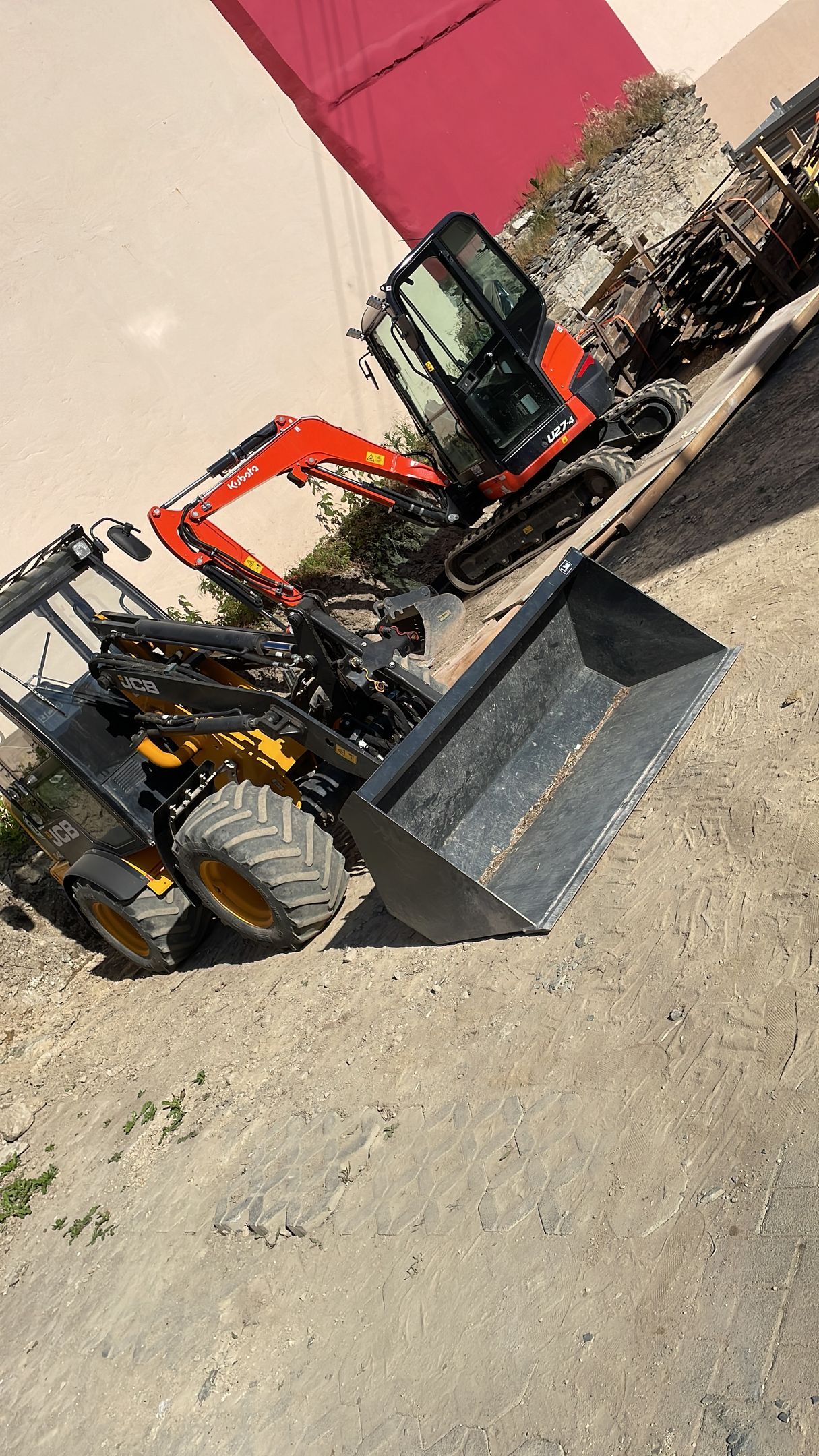 Eine Planierraupe steht neben einem Traktor auf dem Boden.