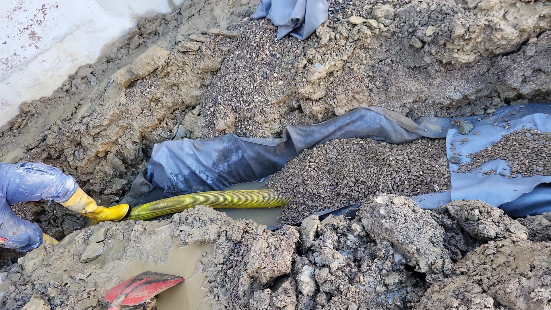 Eine Person gräbt mit einer Schaufel im Dreck.