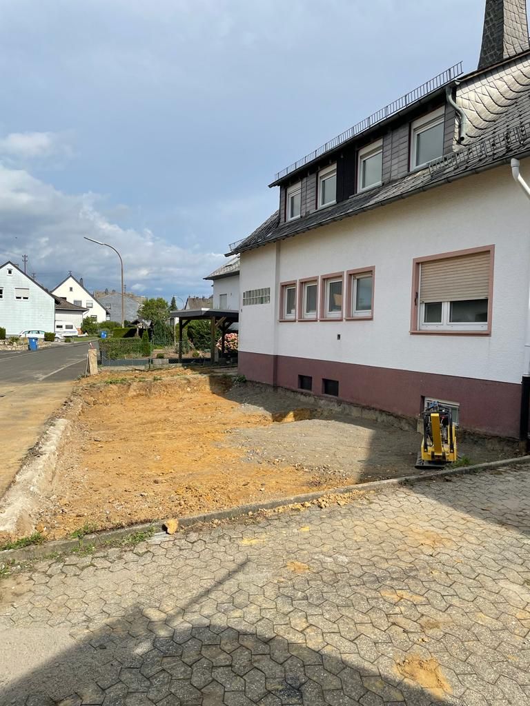 Ein weißes Haus mit viel Dreck davor.