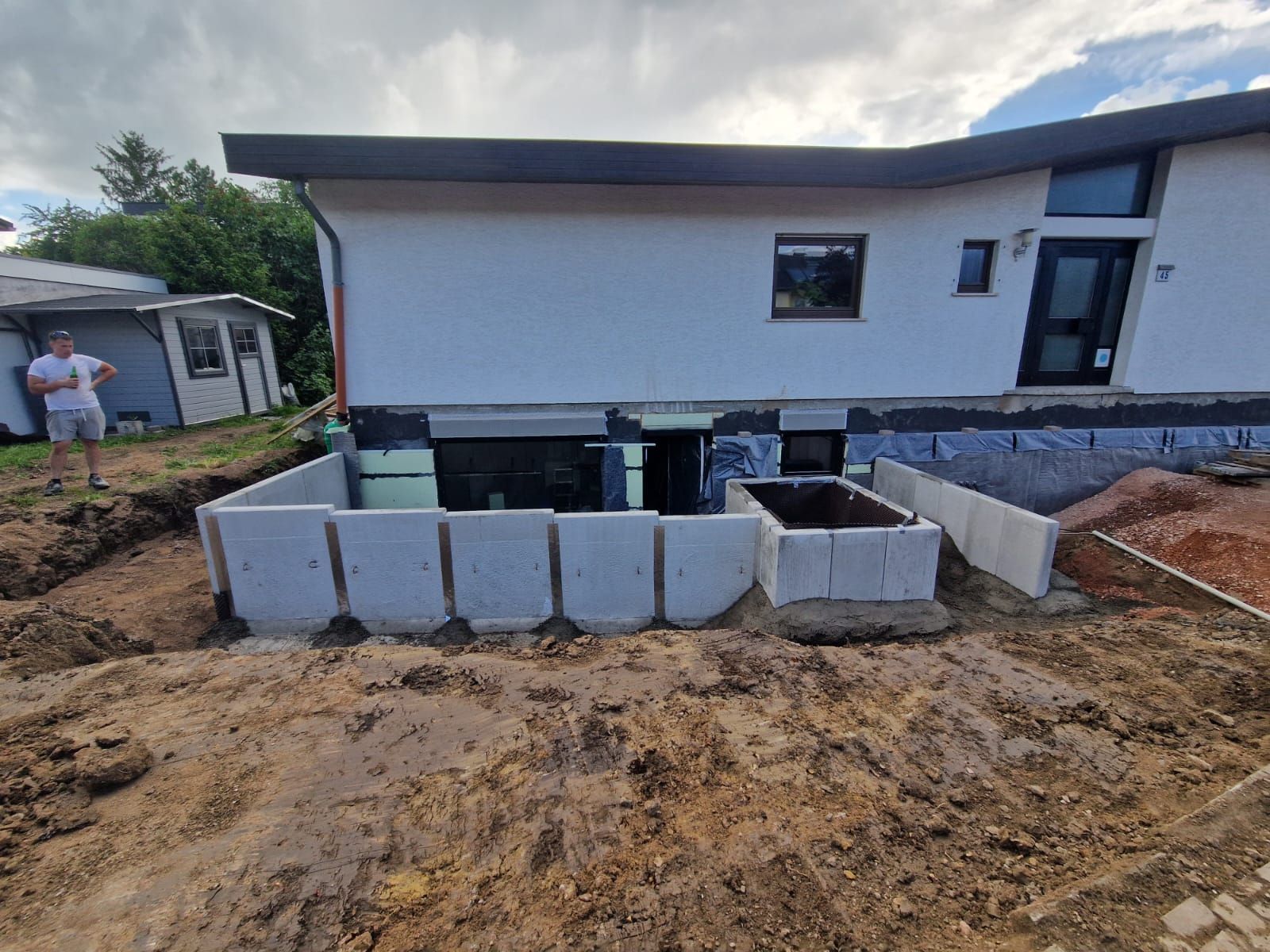 Zwei Bauarbeiter schauen sich auf einer Baustelle einen Bauplan an.