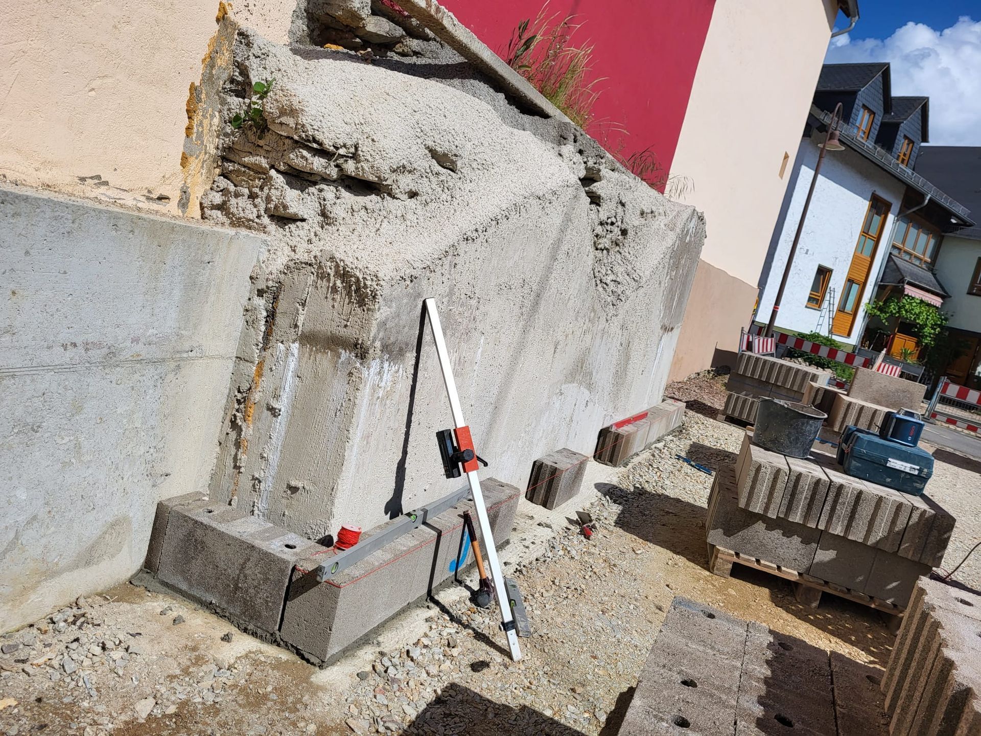 Eine Baustelle mit einer Betonmauer und einem Stativ auf dem Boden.