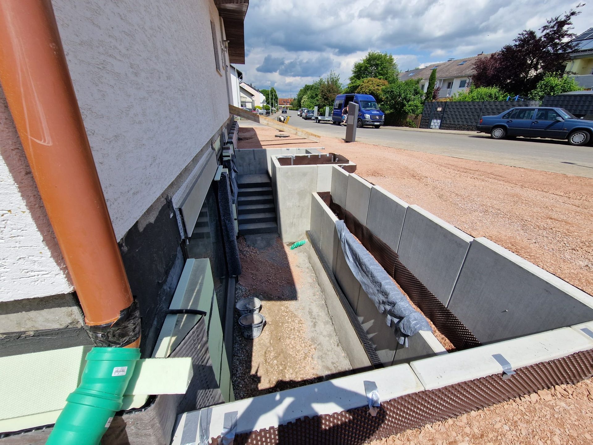 An der Seite eines Hauses wird ein Entwässerungssystem installiert