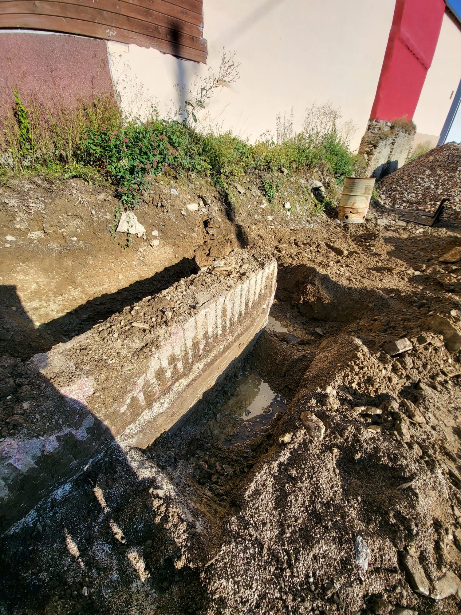 Vor einem Gebäude liegt ein großer Erdhaufen.