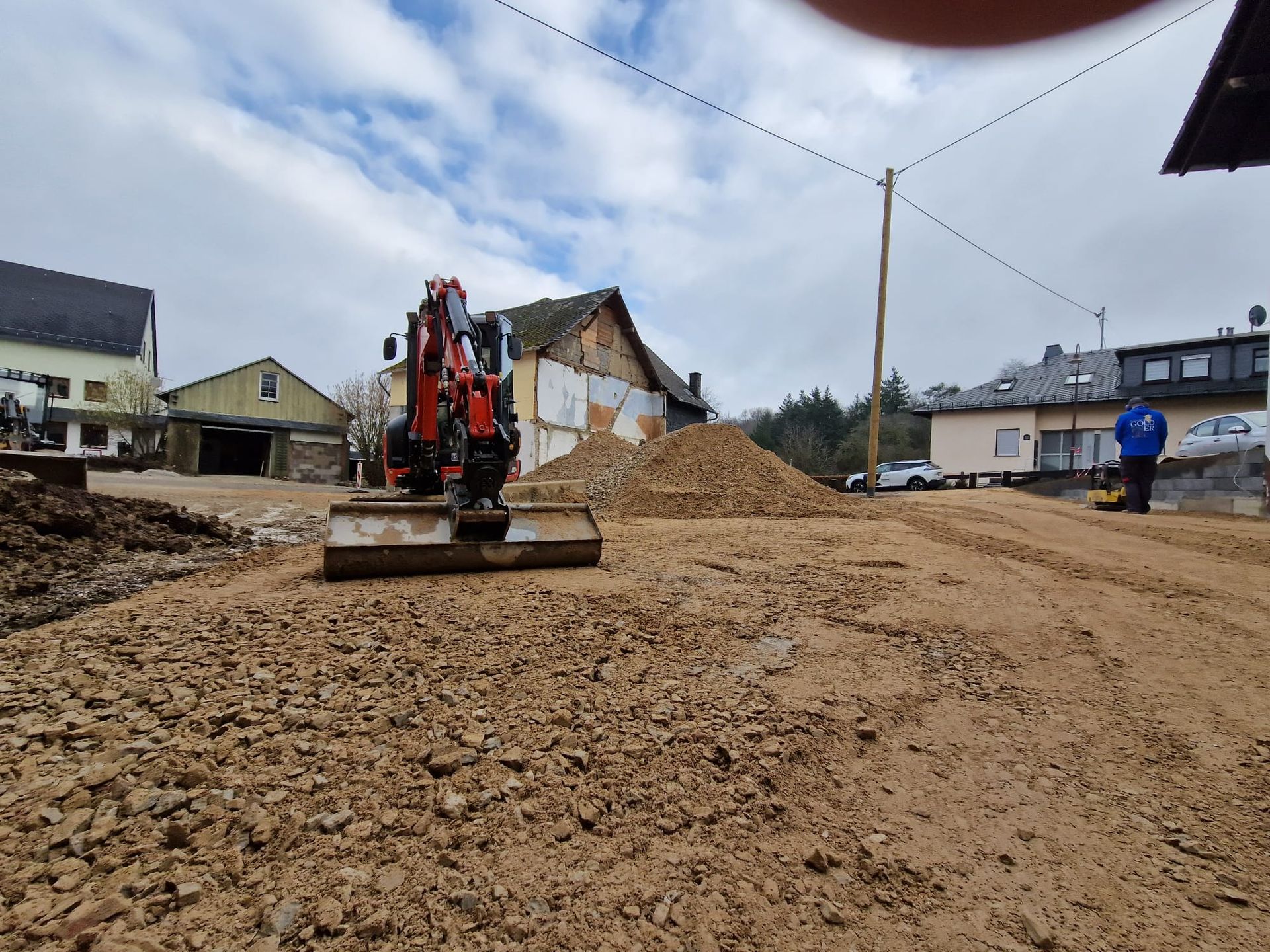 Eine Planierraupe bewegt Erde auf einer unbefestigten Straße.