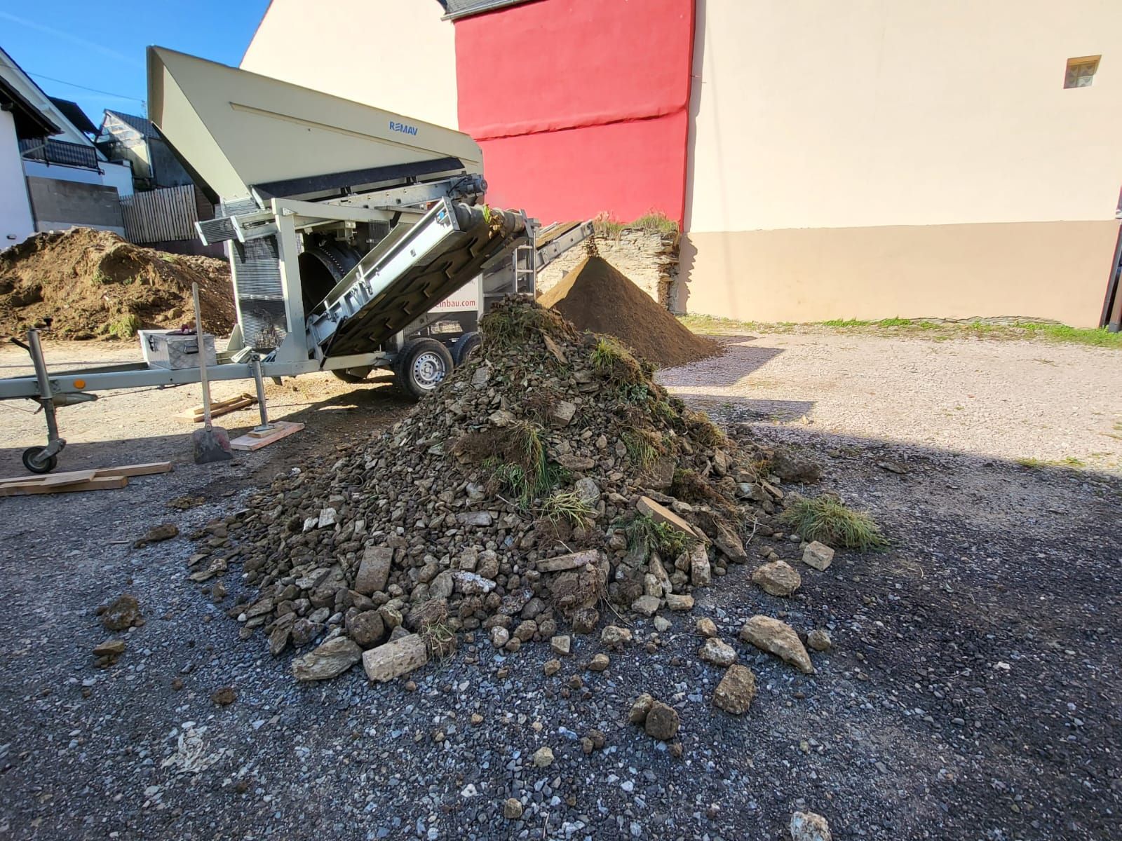 Vor einem Gebäude liegt ein Steinhaufen auf dem Boden.