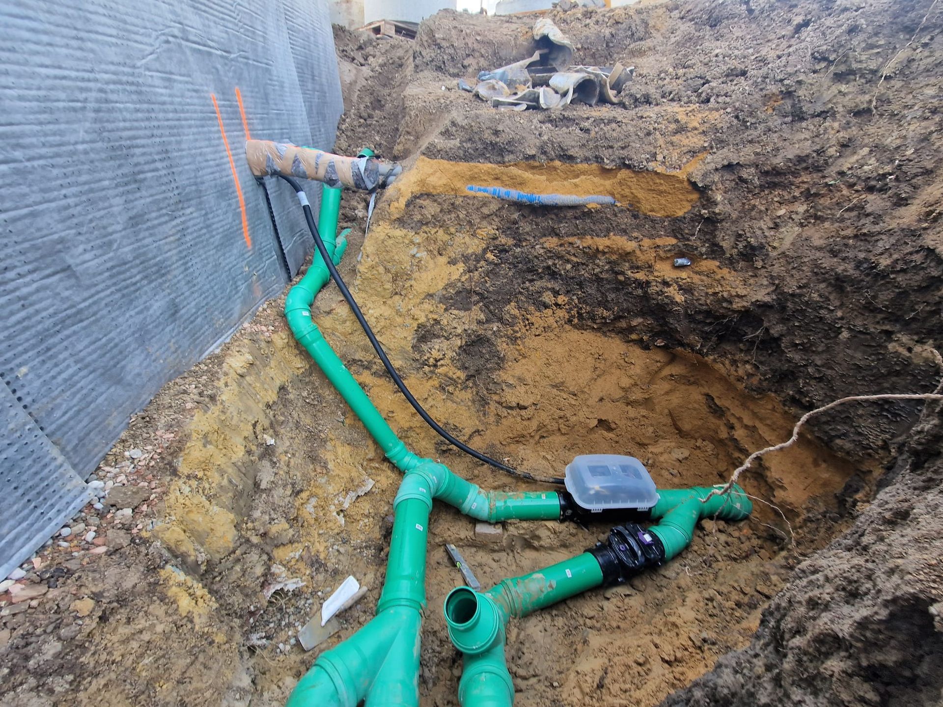 Ein Haufen grüner Rohre liegt im Dreck.