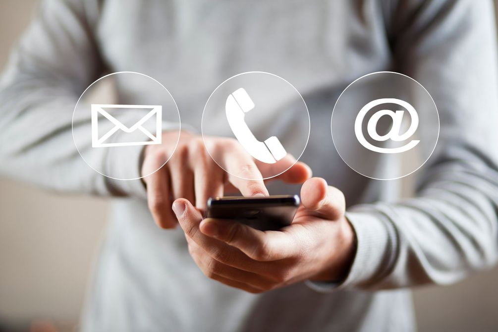 Une personne avec le téléphone et les bulles de téléphone, e-mail et courrier.