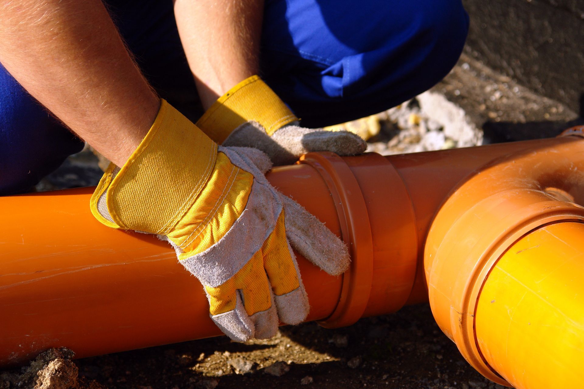 Un professionnel qui tient le tuyau de canalisation.