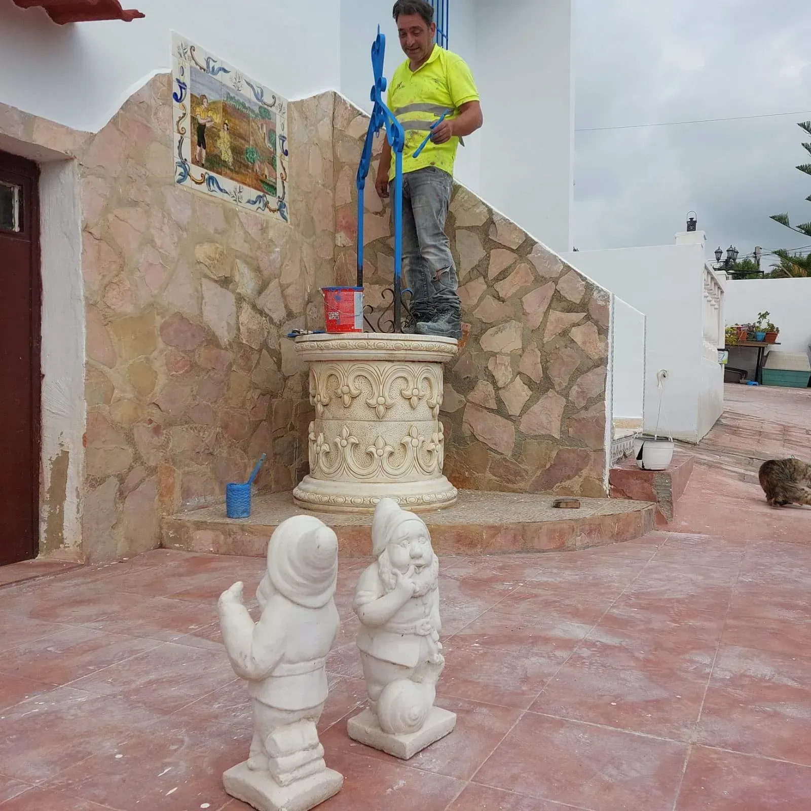 Un hombre con una camisa amarilla está trabajando en una bomba de agua.