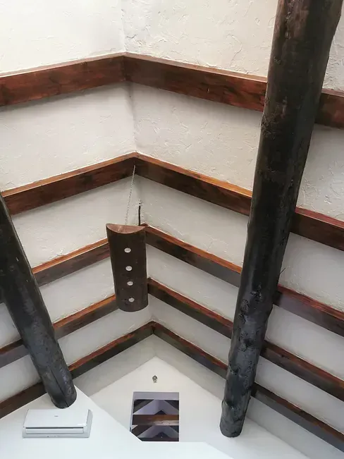 Un techo con vigas de madera y un cuadro en la pared.