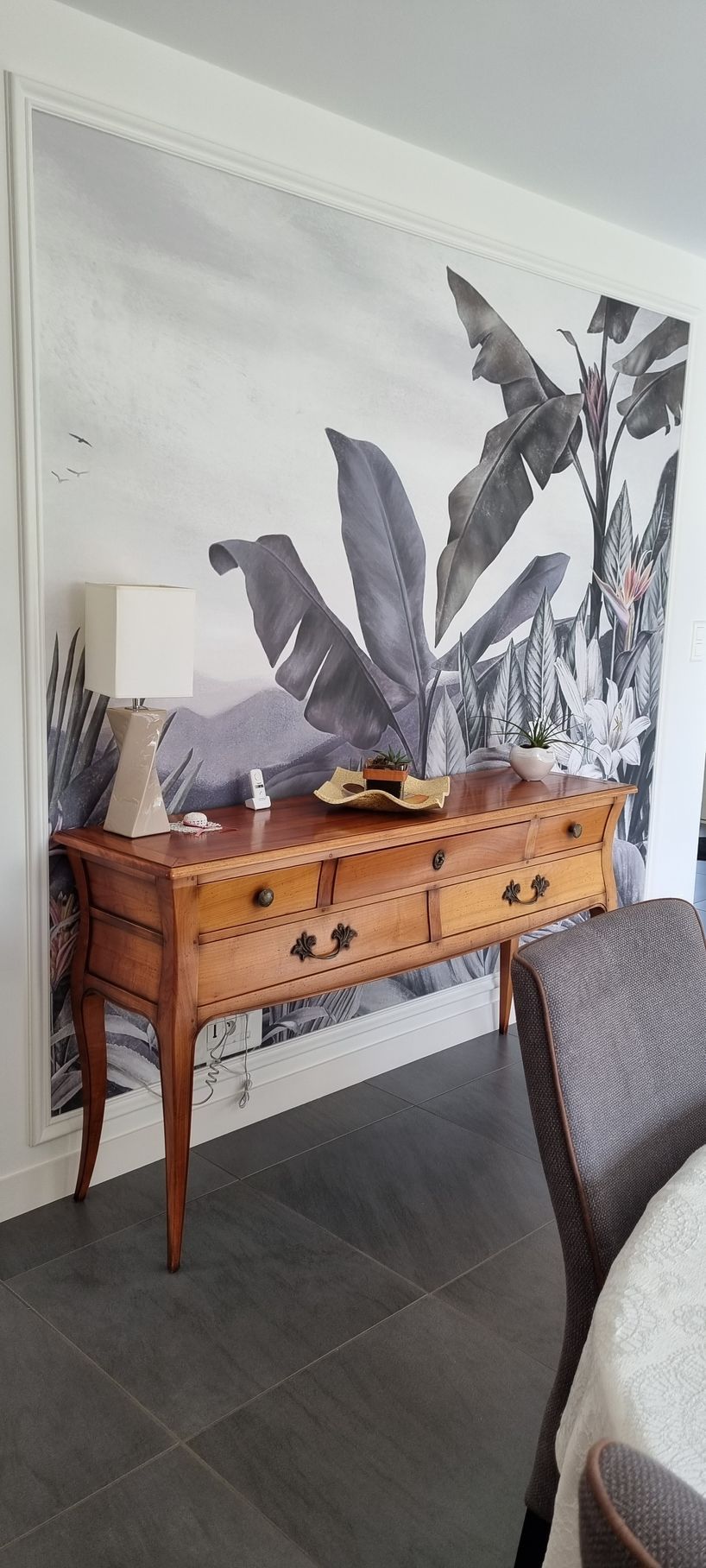 Mur à papier peint végétal avec petit meuble