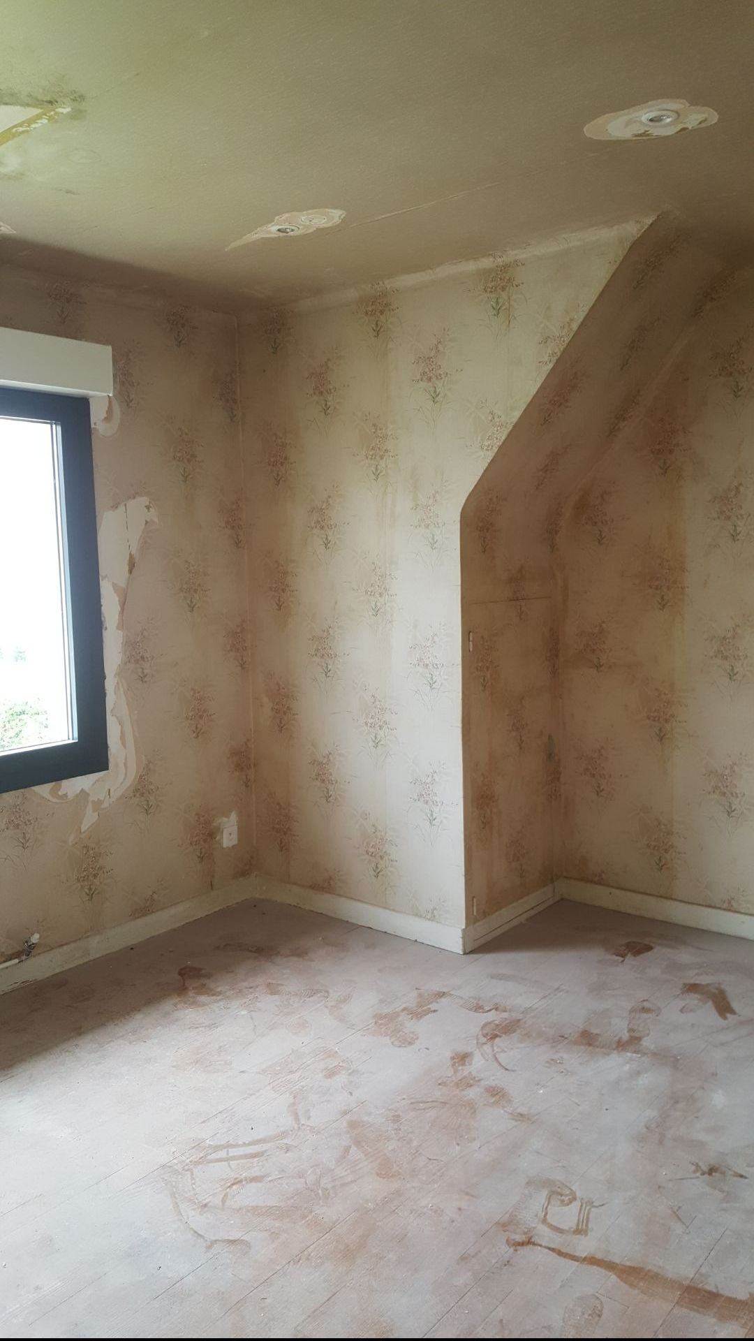 Coin d'une chambre avec un vieux papier peint