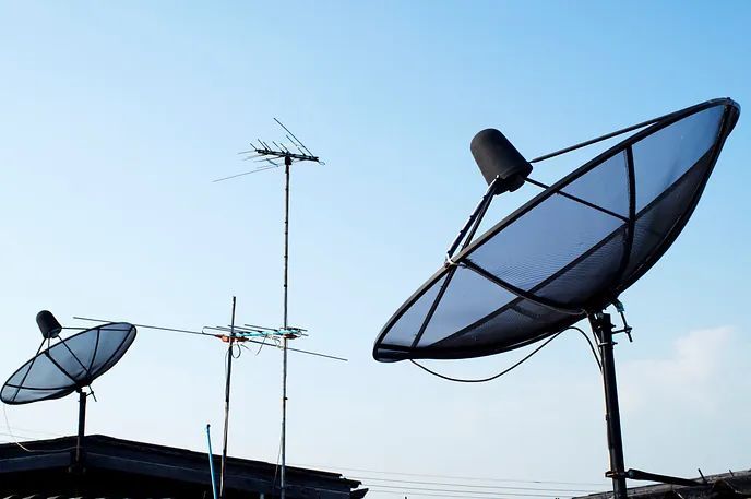 Tres antenas parabólicas están colocadas encima de un tejado.