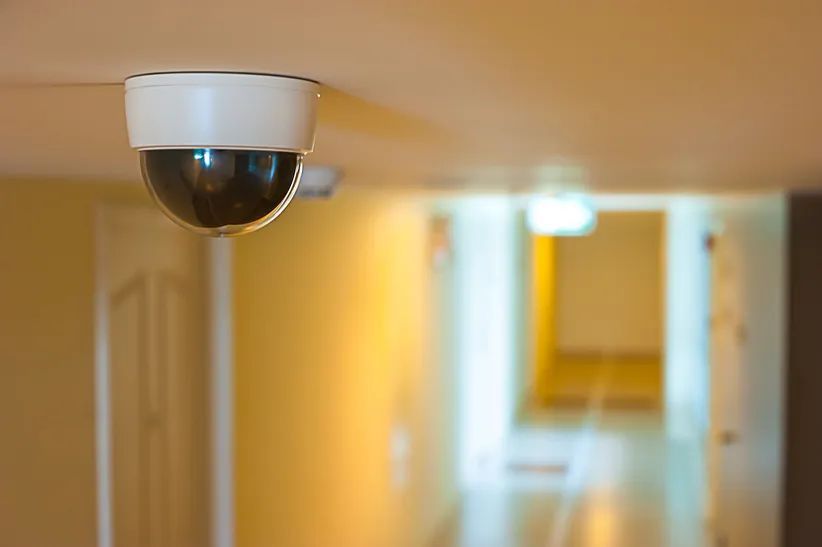Una cámara de seguridad cuelga del techo de un pasillo.