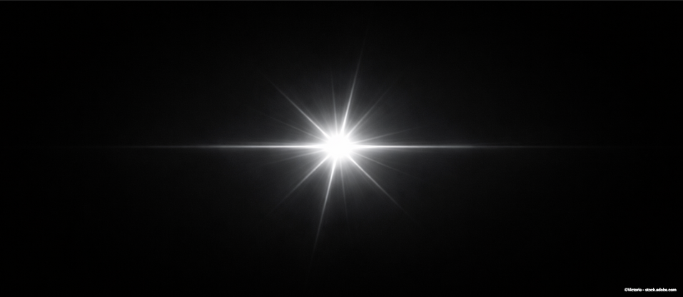 Strahlender Lichtpunkt auf schwarzem Hintergrund mit Sterneneffekt