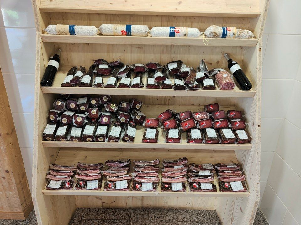 Une étagère en bois remplie de nombreux types d'aliments différents.