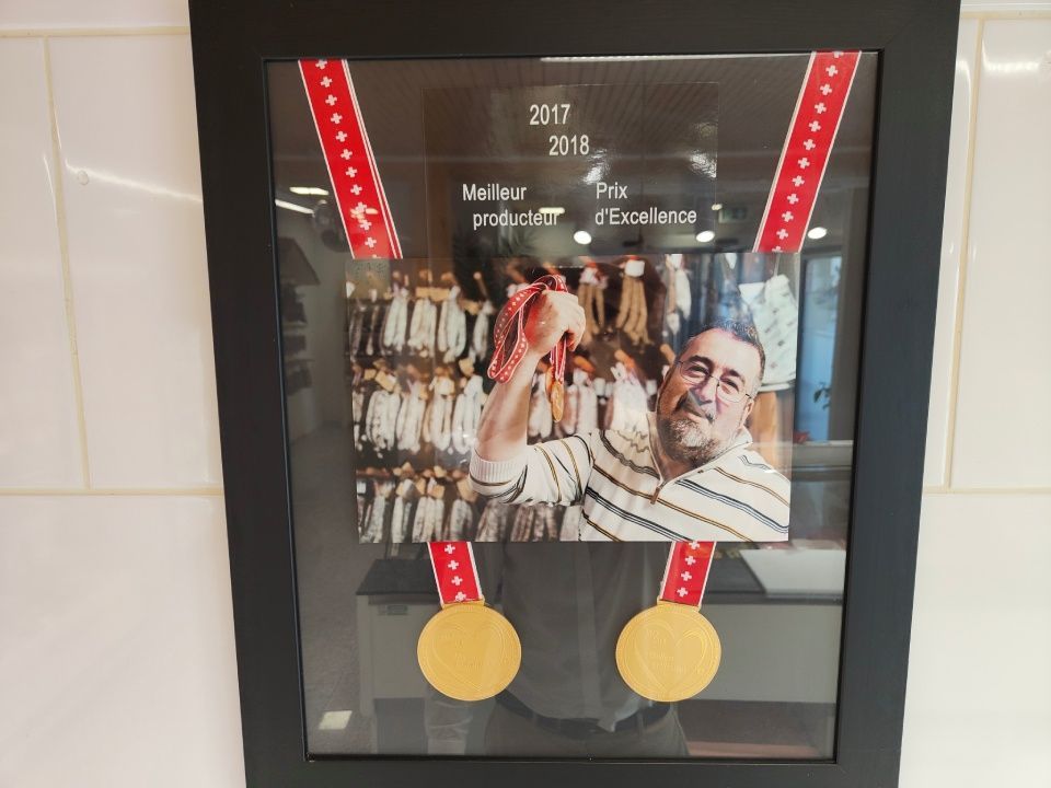 Une photo encadrée d'un homme avec deux médailles d'or autour du cou