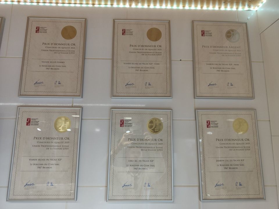 Une rangée de certificats encadrés sur un mur blanc