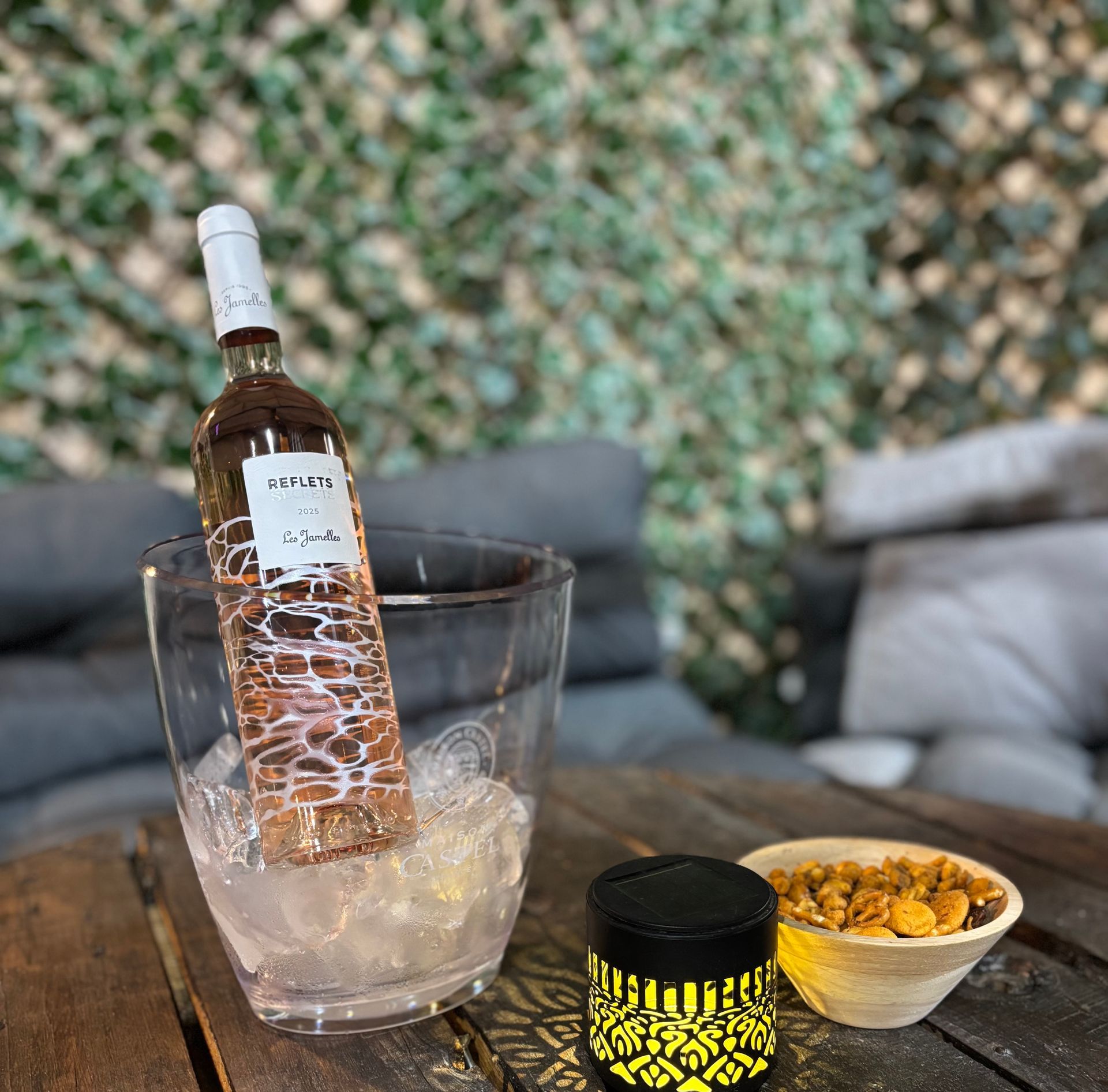 Verser du whisky à la main dans un verre, avec des lumières ambrées en arrière-plan.