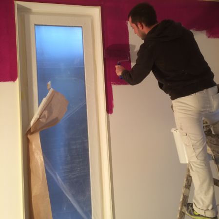 Mitarbeiter von Bernet Maler streicht eine Wand