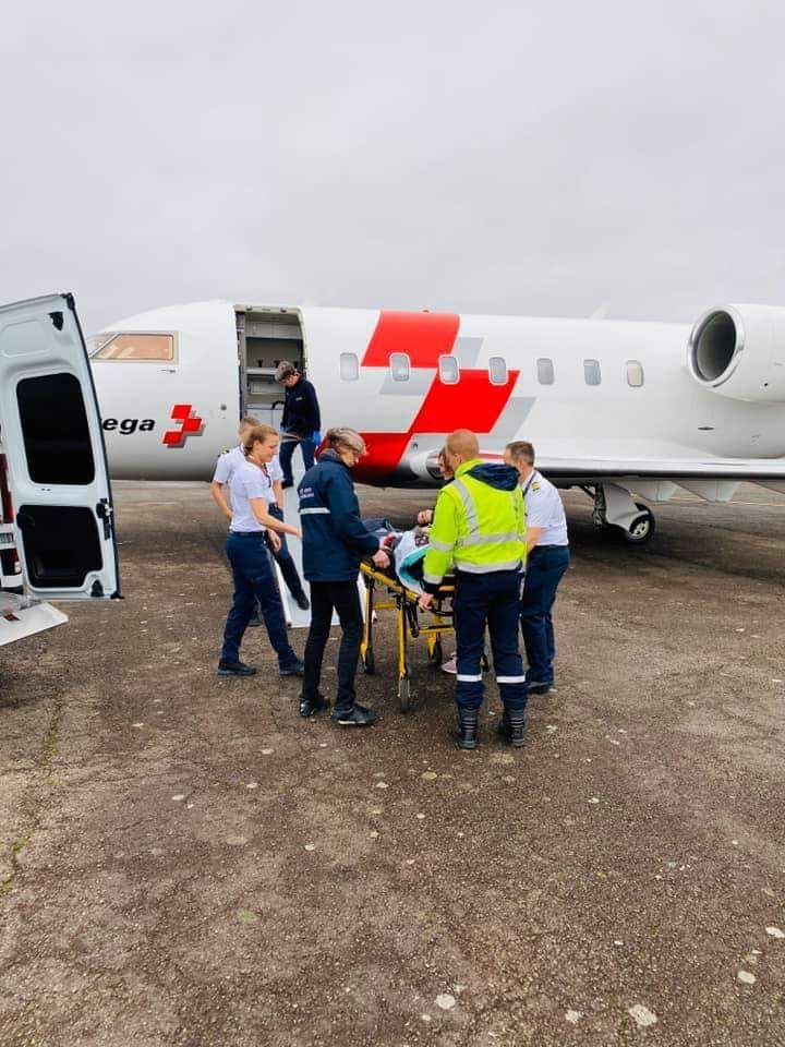 Un blessé sur un brancard est transporté d'un avion à une ambulance