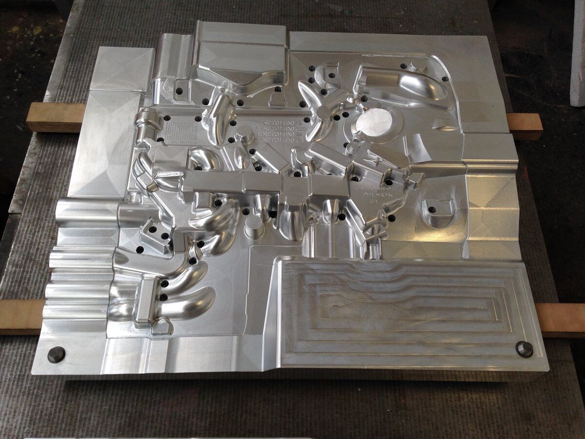 Auf einem Holztisch liegt eine Metallform.