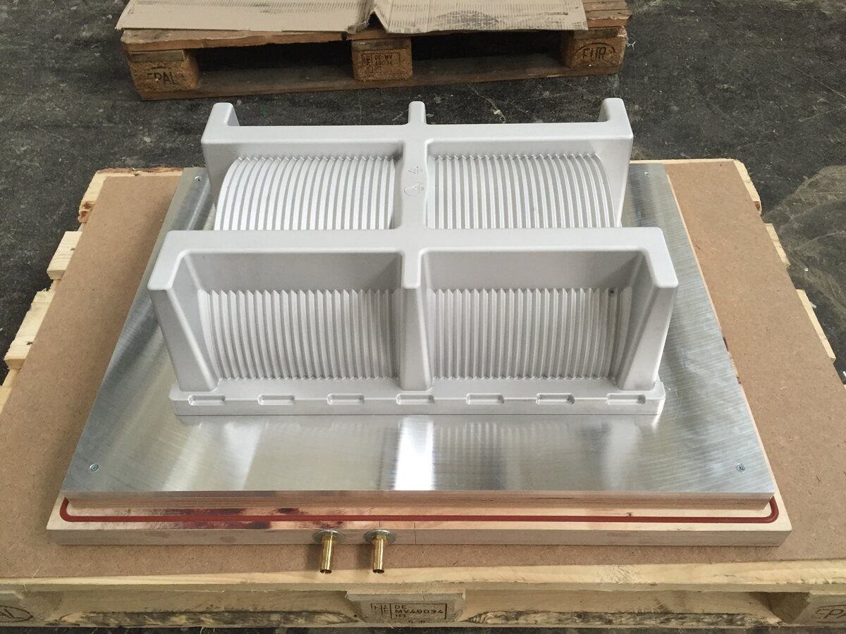 Auf einer Holzpalette liegt ein Metallgegenstand.