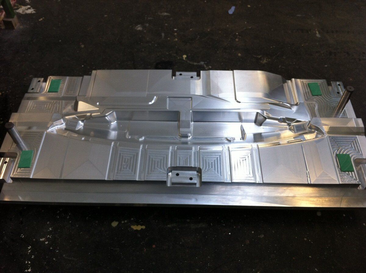 Auf einer schwarzen Oberfläche liegt eine Metallform.