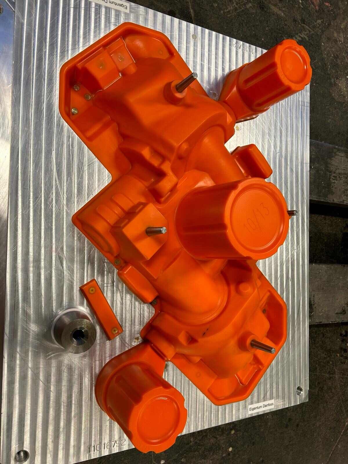 Ein orangefarbener Prototyp liegt auf einer Metalloberfläche
