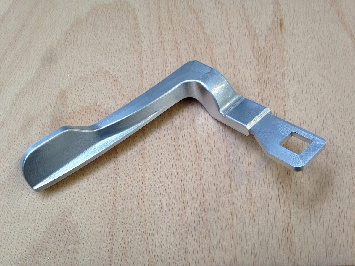 Ein Metallgegenstand liegt auf einer Holzoberfläche