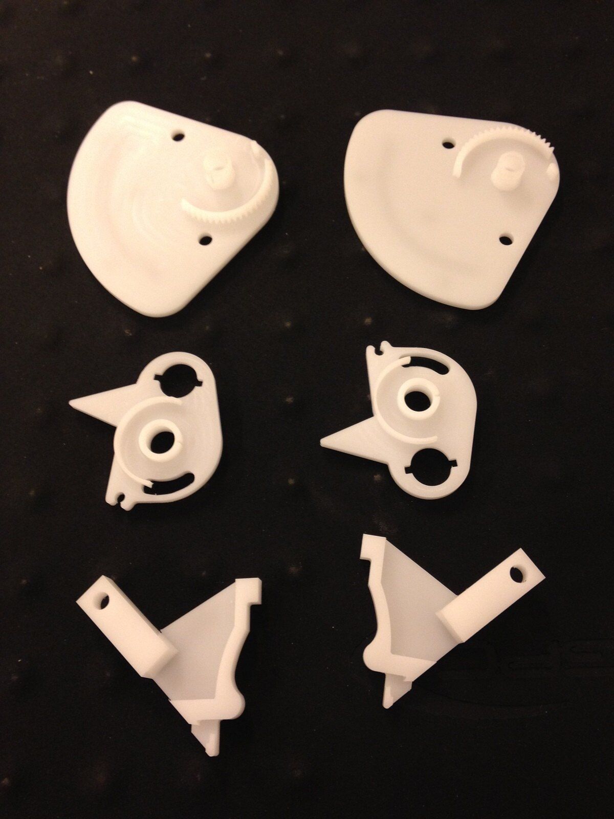 Ein Haufen weißer Plastikteile auf schwarzem Untergrund