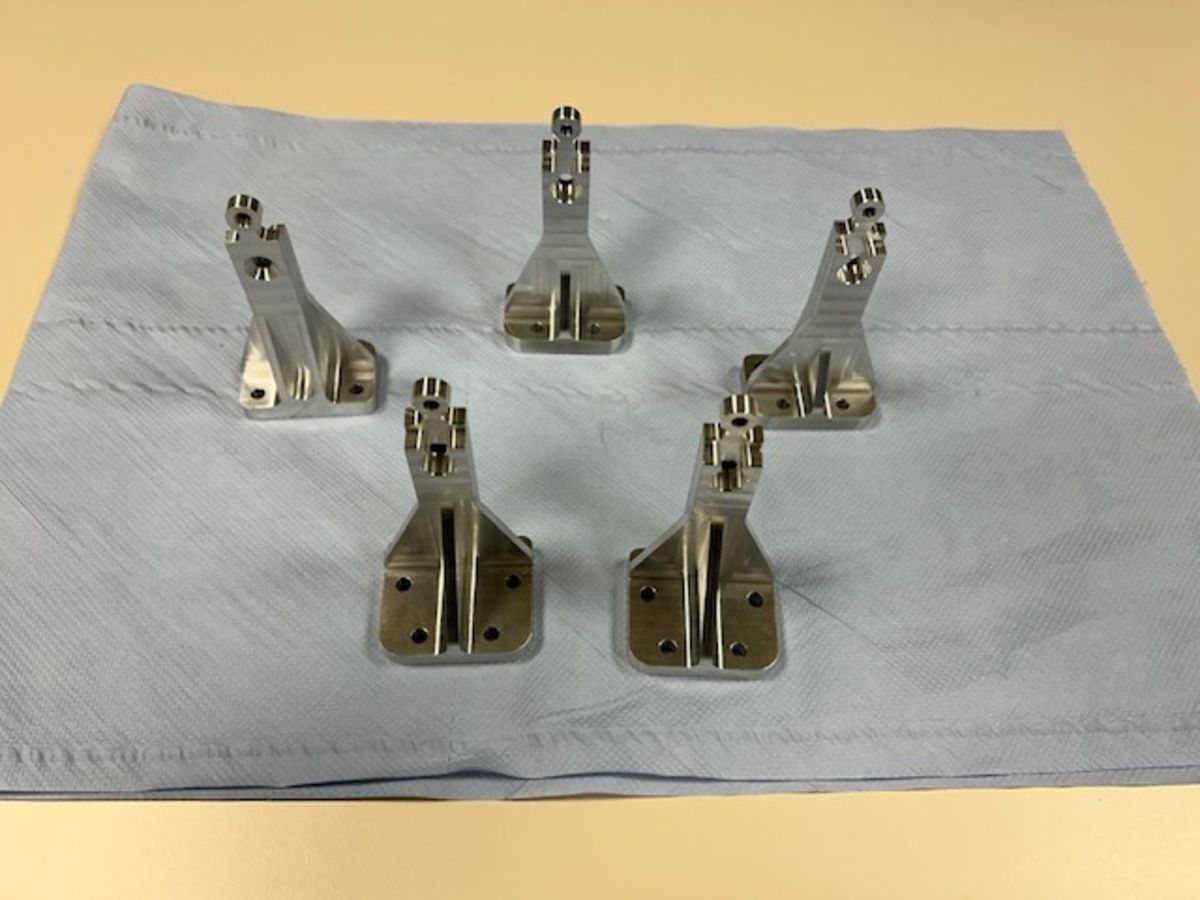 Eine Gruppe von Metallteilen liegt auf einem weißen Tuch.