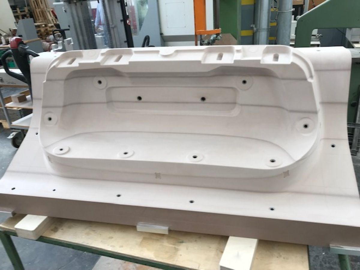 Ein großer weißer Prototyp liegt auf einem Holztisch.