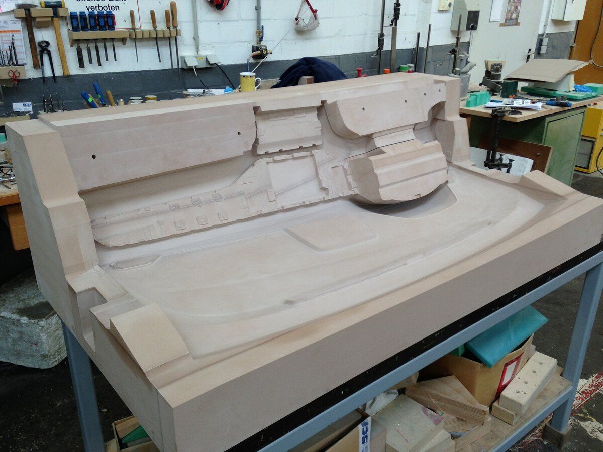 Ein großes Stück Holz liegt auf einem Tisch in einer Werkstatt.