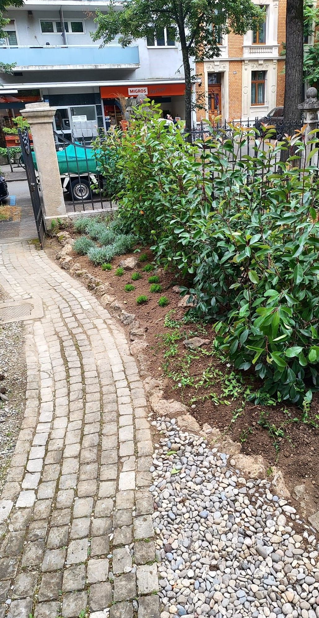 Ein Backsteinweg, der zu einem Gebäude in einem Park führt.