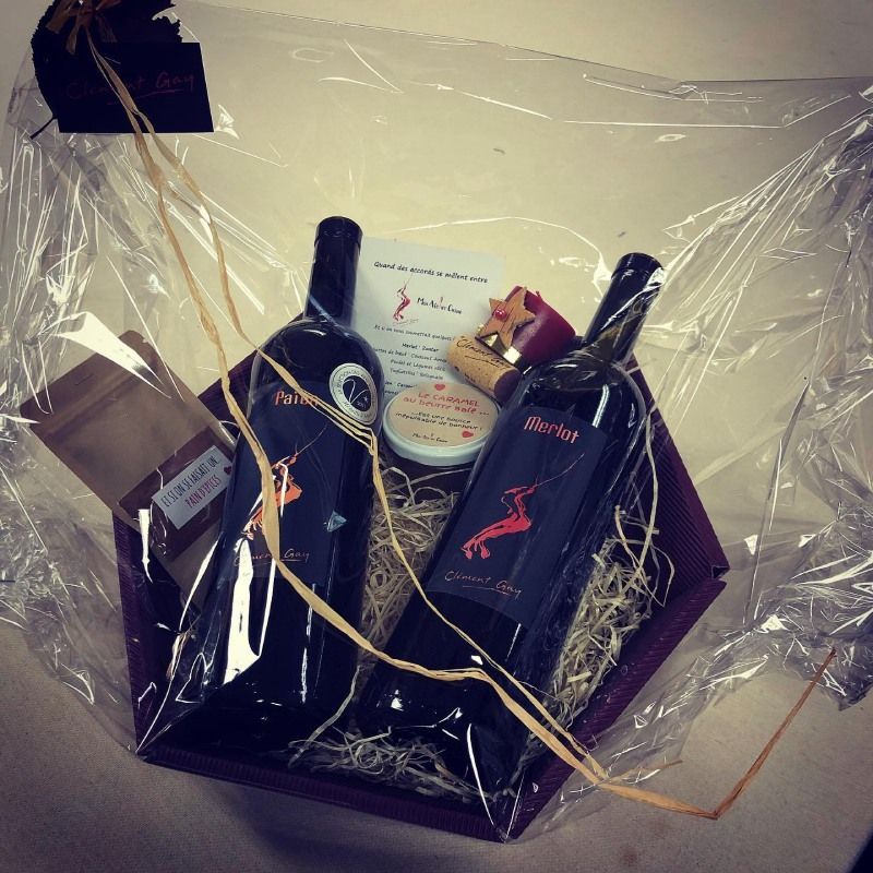 Un panier cadeau avec deux bouteilles de vin et une carte cadeau