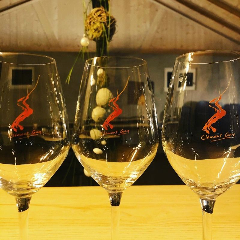 Trois verres à vin sont alignés sur une table en bois