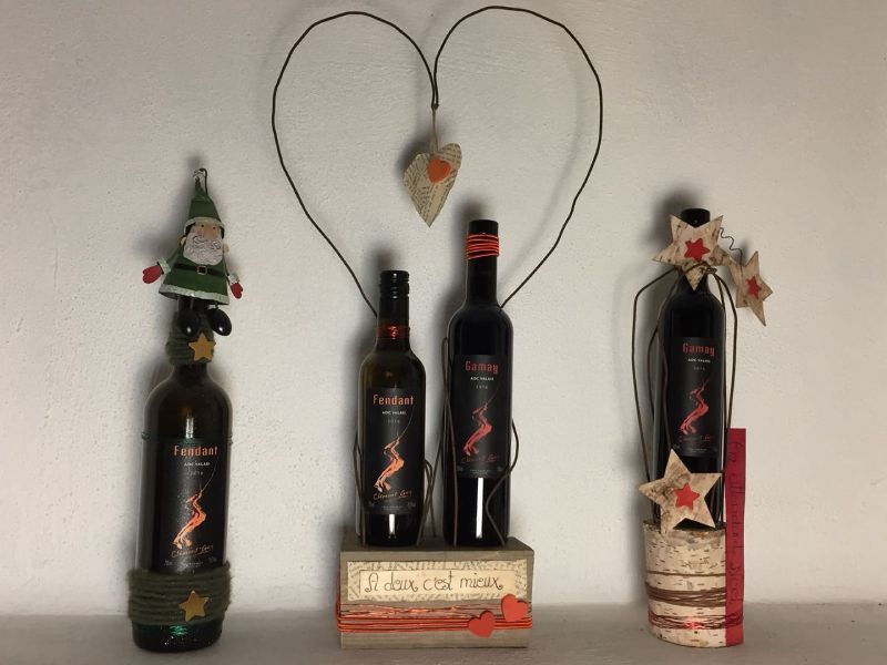 Trois bouteilles de vin et une décoration en forme de cœur