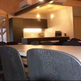 Un restaurant avec des tables et des chaises et une cuisine en arrière-plan.