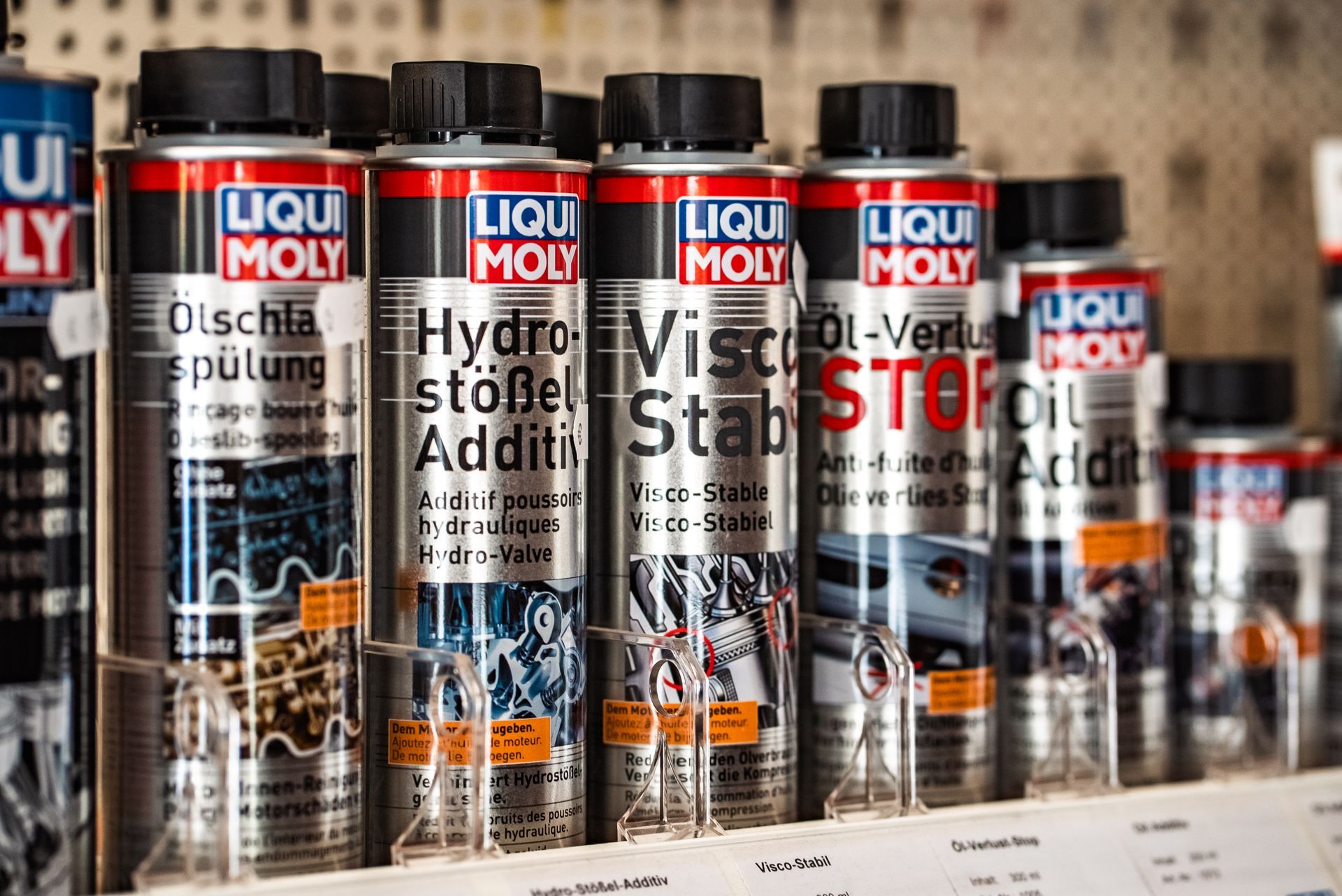 Mehrere Flaschen Liqui Moly stehen aufgereiht auf einem Regal