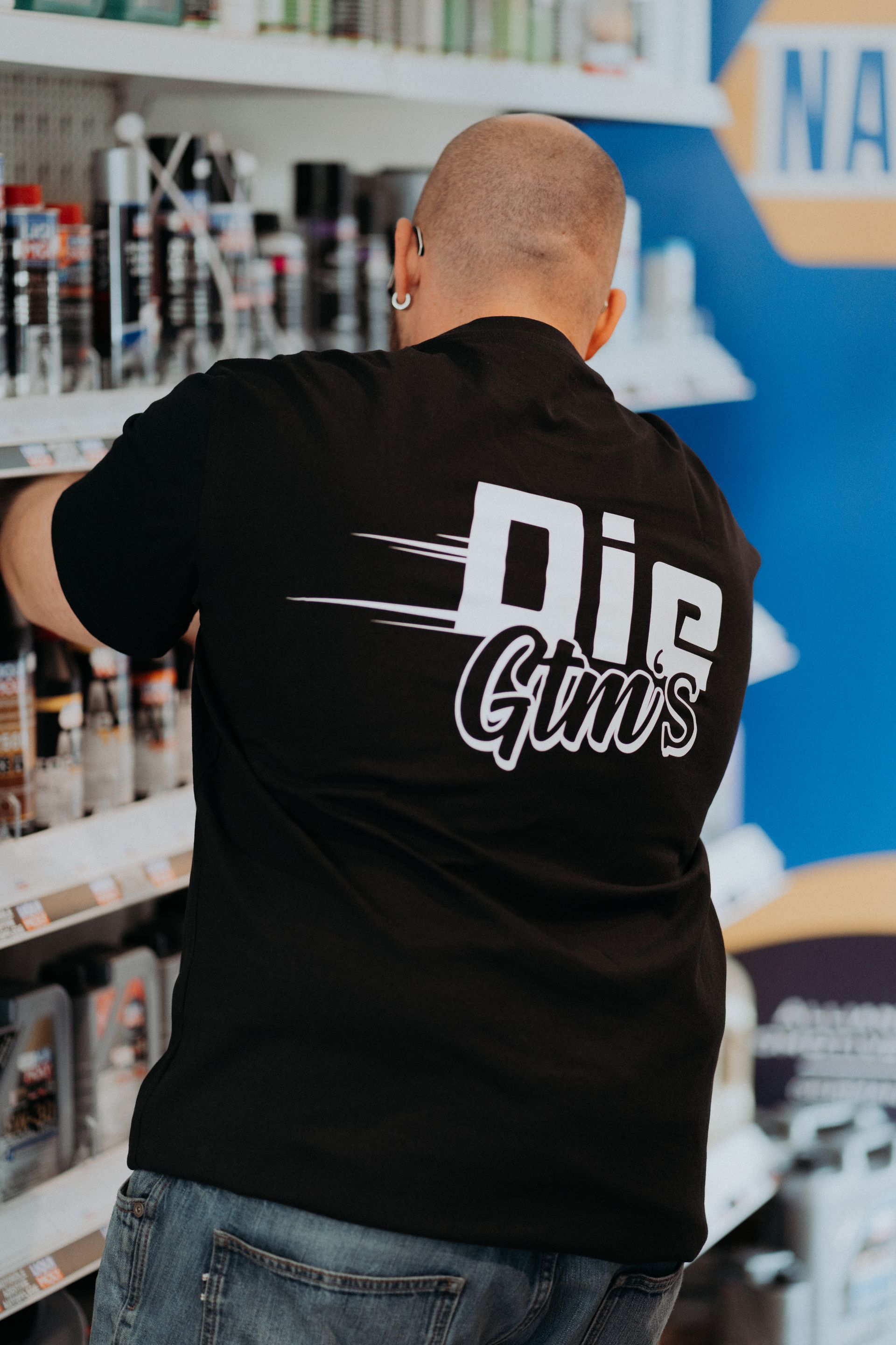 Ein Mann, der ein schwarzes T-Shirt mit der Aufschrift „Stirb deinen Mut“ trägt