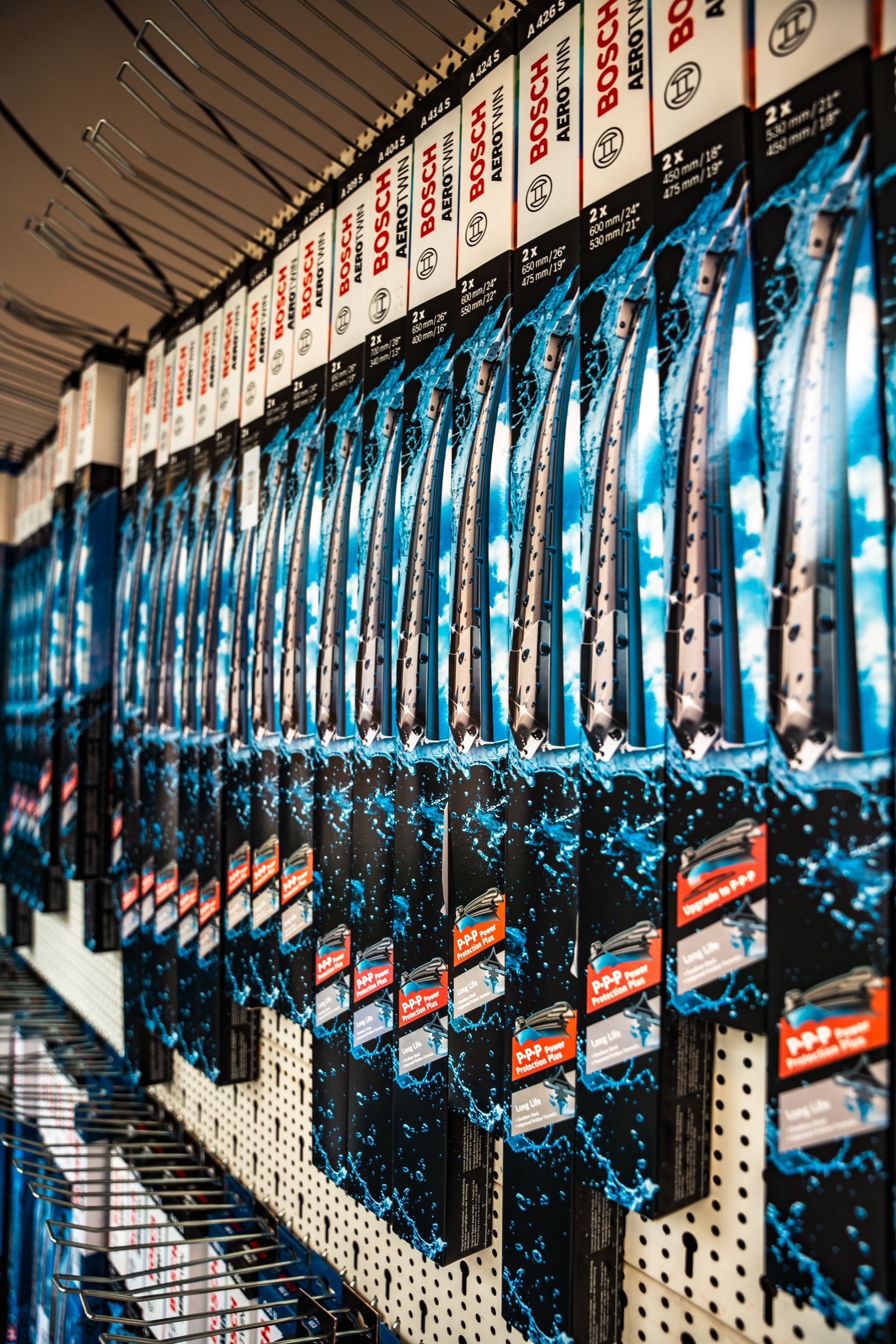 In einem Geschäft sind auf einem Regal mehrere Wischerblätter aufgereiht.