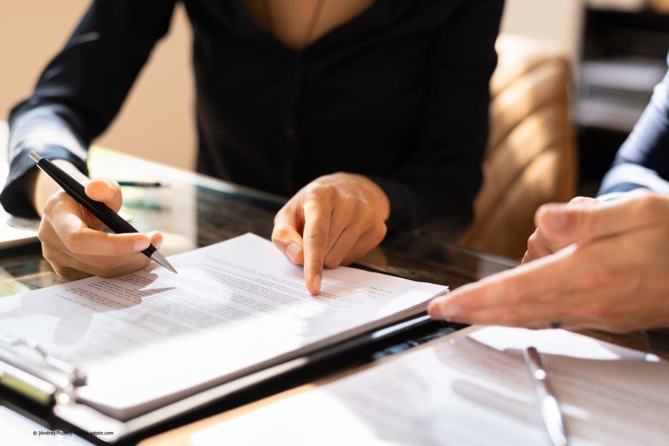 Rechtsanwältin Iris Harff, Hand tippt auf Unterlage am Tisch