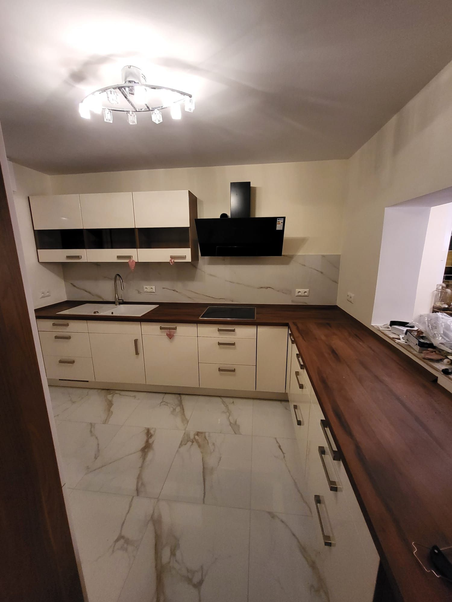 Eine Küche mit weißen Schränken und Holzarbeitsplatten