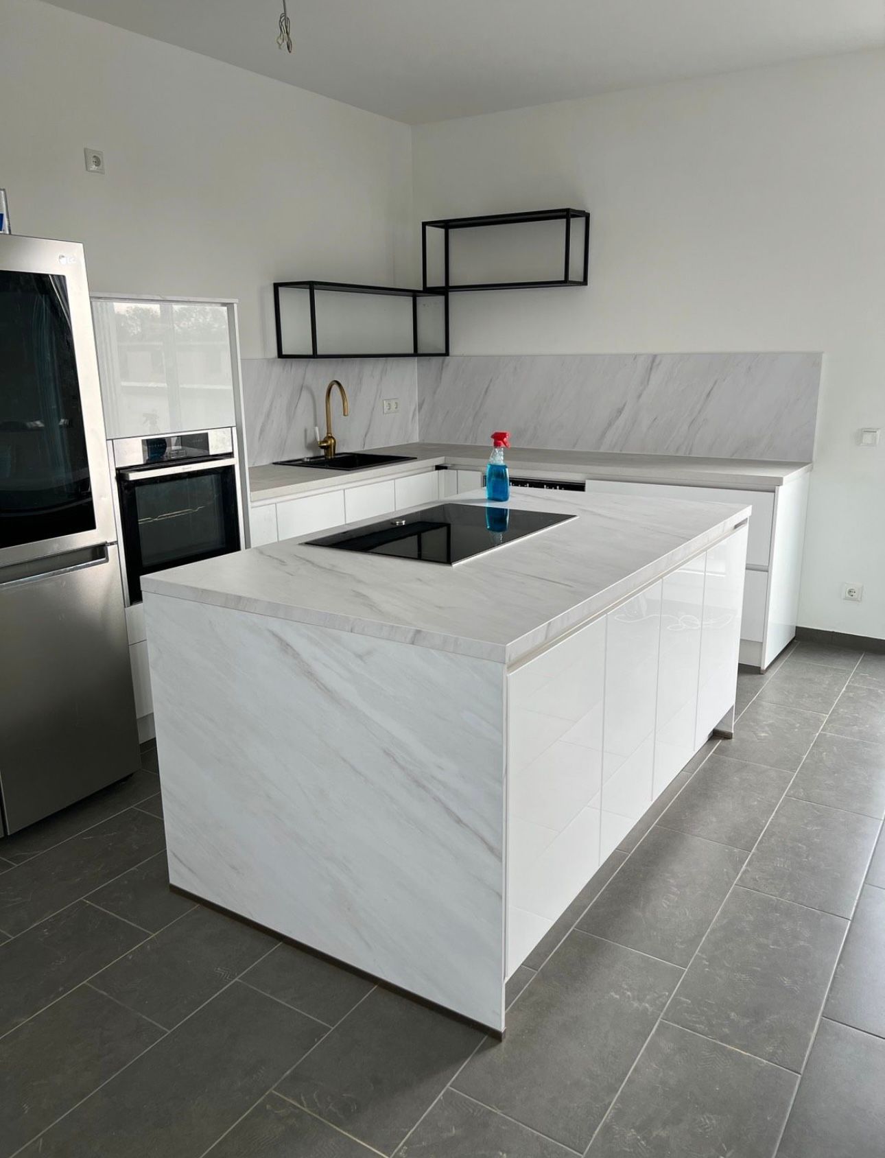 Eine Küche mit weißen Schränken, Edelstahlgeräten und einer großen Insel