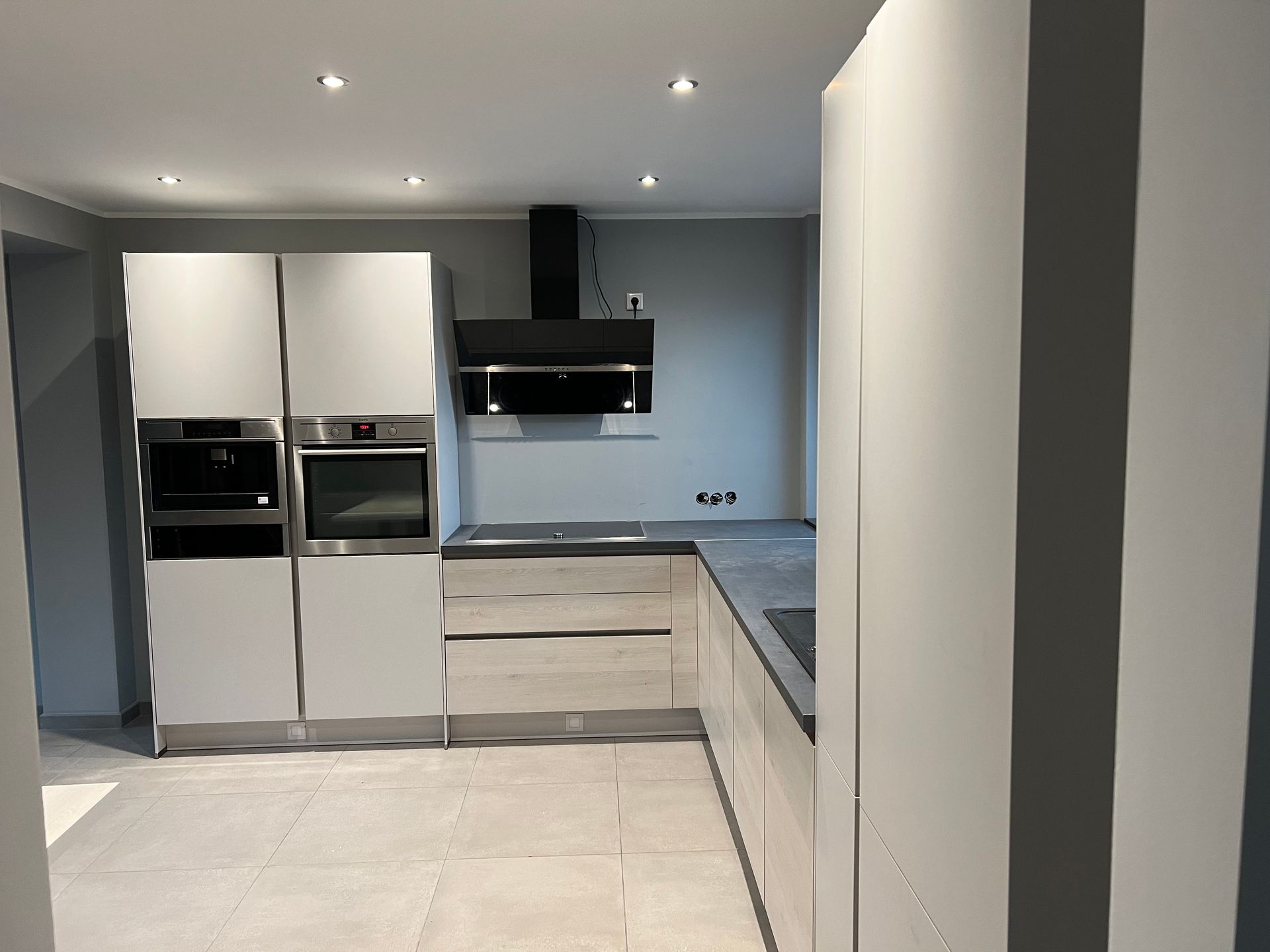 Eine Küche mit weißen Schränken und Edelstahlgeräten